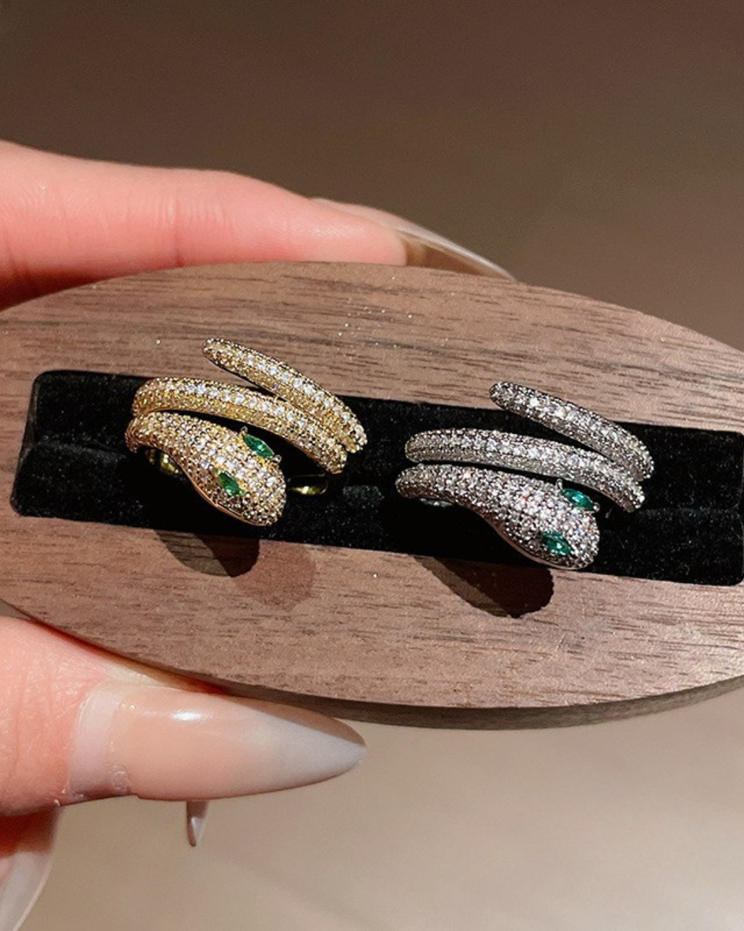 Nahyra Ring – Anel serpente cravejado com olhos verdes, disponível em dourado e prateado