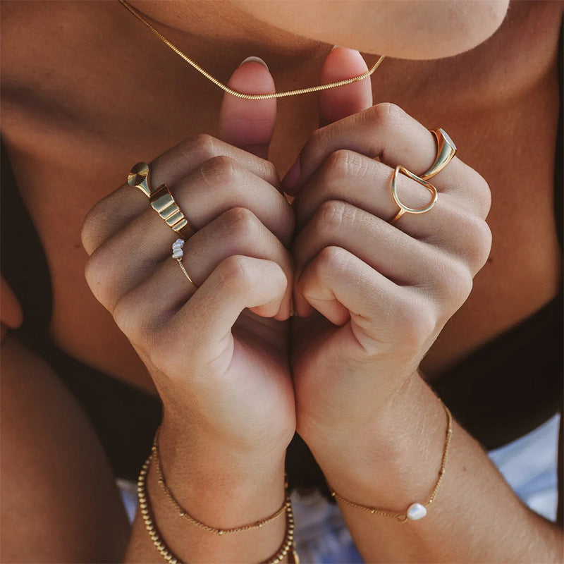 Aluna Ring – Anel moderno com forma orgânica vazada e acabamento dourado polido
